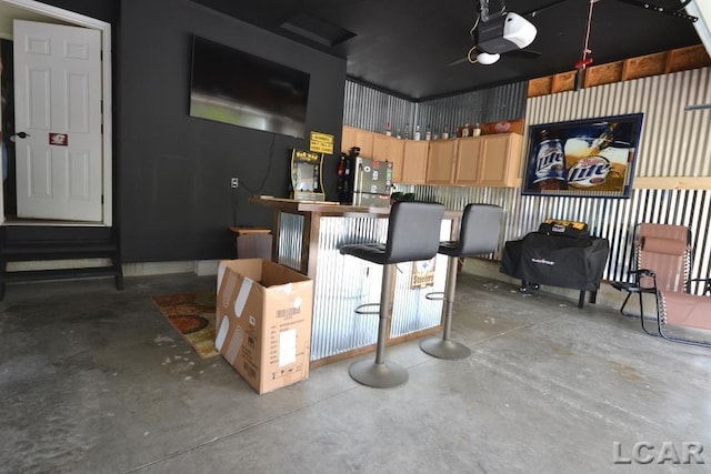 1872 Allan St, Adrian, MI 49221 - kitchen featuring concrete flooring, light brown cabinetry, and freestanding refrigerator