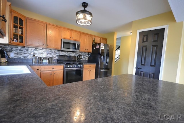 1872 Allan St, Adrian, MI 49221 - kitchen with appliances with stainless steel finishes, a sink, glass insert cabinets, dark countertops, and decorative backsplash