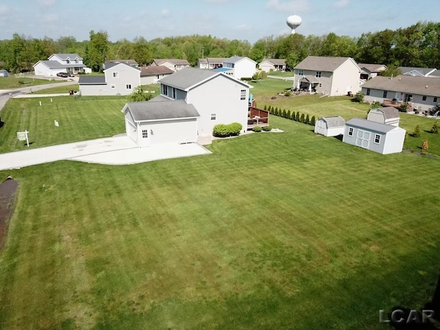 1872 Allan St, Adrian, MI 49221 - view of grassy yard featuring a residential view, an outdoor structure, and a storage unit