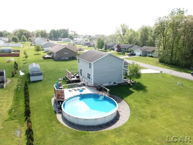 1872 Allan St, Adrian, MI 49221 - swimming pool with a wooden deck, a lawn, and a residential view