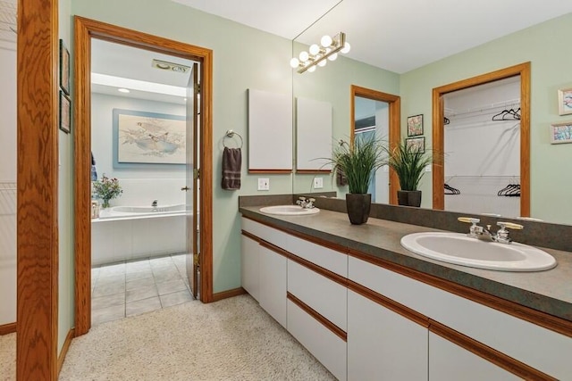 10059 Weko Dr, Bridgman, MI 49106 - full bath with double vanity, a bath, a walk in closet, and baseboards