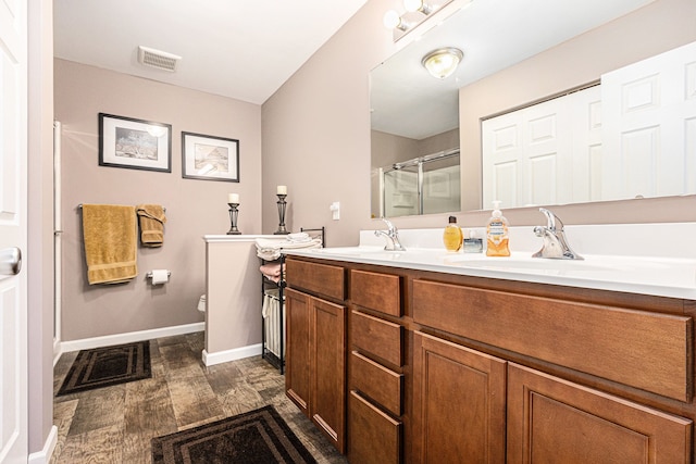 754 Autumn Valley Dr, Ortonville, MI 48462 - bathroom with wood finished floors, a shower stall, double vanity, toilet, and baseboards