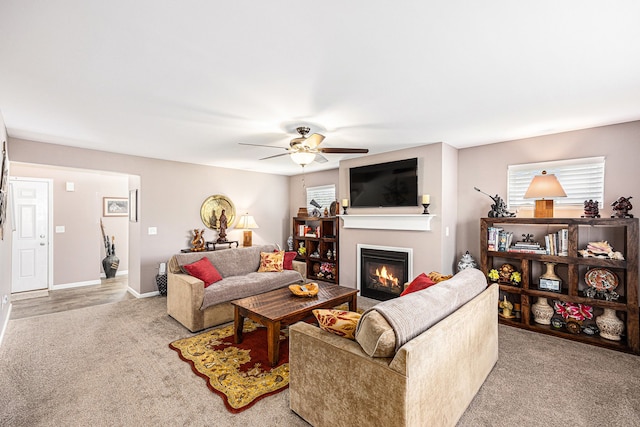 754 Autumn Valley Dr, Ortonville, MI 48462 - living room featuring light carpet, a glass covered fireplace, a ceiling fan, and baseboards