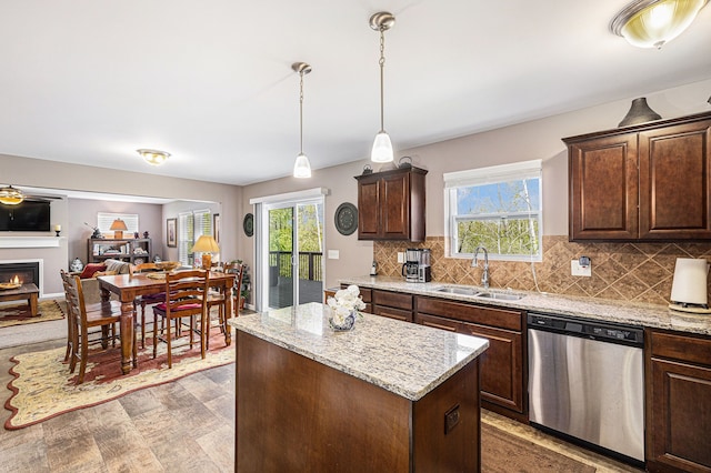 754 Autumn Valley Dr, Ortonville, MI 48462 - kitchen with stainless steel dishwasher, a sink, a center island, decorative backsplash, and light stone counters