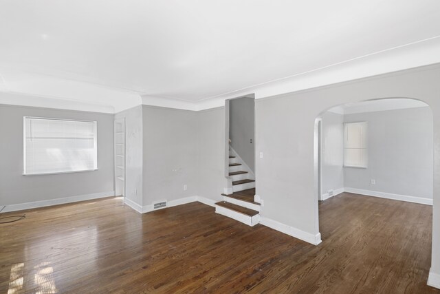 14643 Penrod St, Detroit, MI 48223 - unfurnished living room with arched walkways, wood finished floors, stairway, baseboards, and ornamental molding
