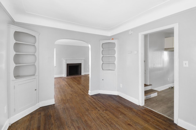 14643 Penrod St, Detroit, MI 48223 - empty room featuring arched walkways, dark wood-style floors, a brick fireplace, and stairway