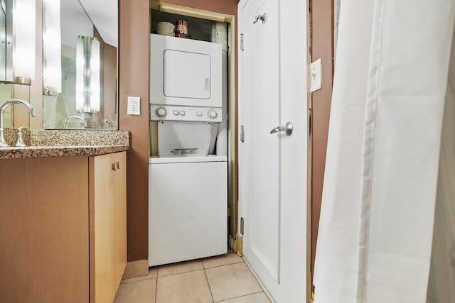 300 Riverfront Dr Unit 300/4C, Detroit, MI 48226 - washroom with stacked washer and clothes dryer and light tile patterned flooring