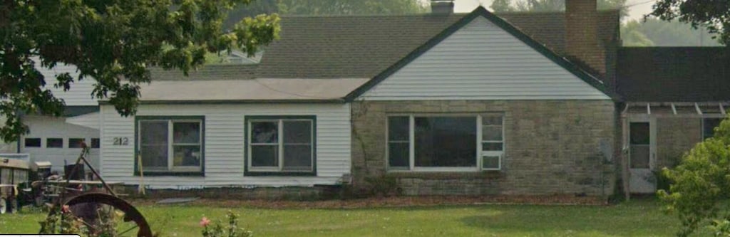 212 Grant St, Galien, MI 49113 - back of property featuring a chimney, a lawn, and stone siding