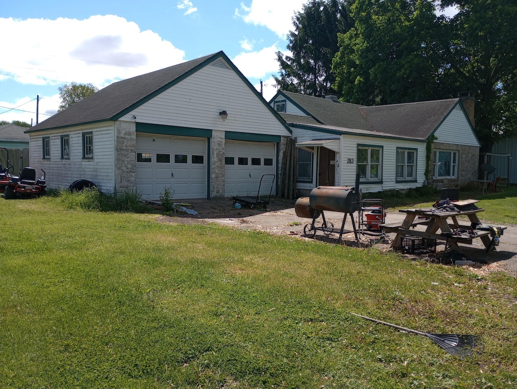 212 Grant St, Galien, MI 49113 - view of front of home featuring stone siding, a garage, and a front yard