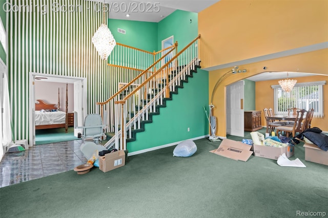 441 Parkview Dr, Detroit, MI 48214 - stairway with a chandelier, a high ceiling, carpet floors, arched walkways, and baseboards