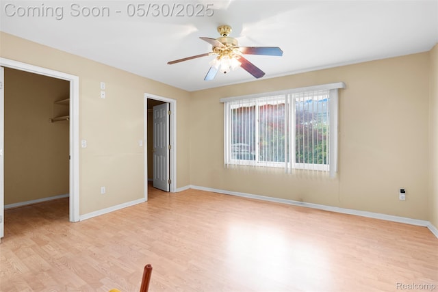 441 Parkview Dr, Detroit, MI 48214 - unfurnished bedroom featuring a walk in closet, light wood-style floors, baseboards, a closet, and ceiling fan