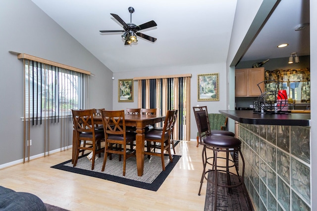2761 Tomahawk Dr, Waterford, MI 48328 - dining space with light wood-type flooring, lofted ceiling, baseboards, ceiling fan, and a dry bar