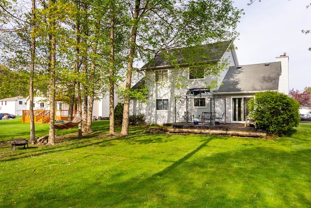 2761 Tomahawk Dr, Waterford, MI 48328 - back of property featuring a yard, a chimney, and a deck