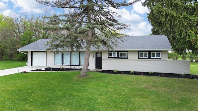 ranch-style home featuring a front lawn, a garage, concrete driveway, and a shingled roof
