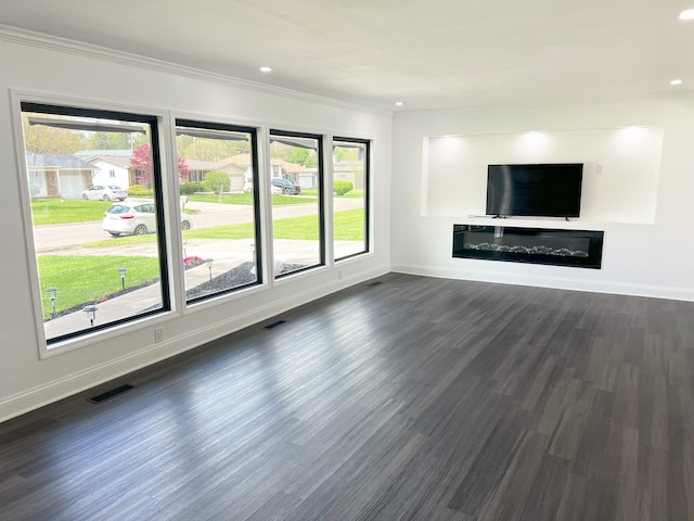 unfurnished living room with baseboards, dark wood-style floors, recessed lighting, and ornamental molding