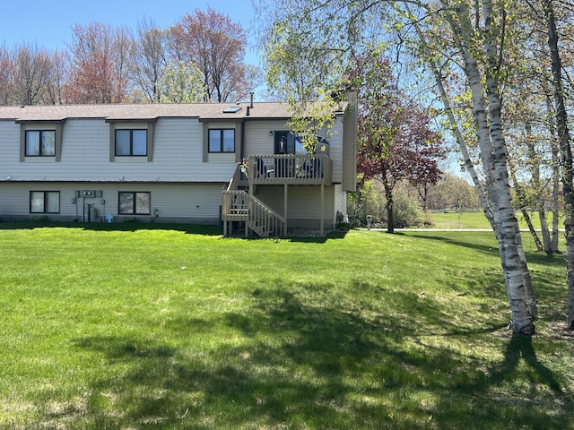 back of house with a wooden deck, stairway, and a yard