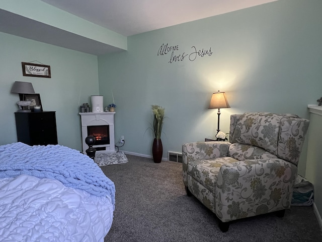 bedroom featuring carpet flooring, baseboards, and a lit fireplace