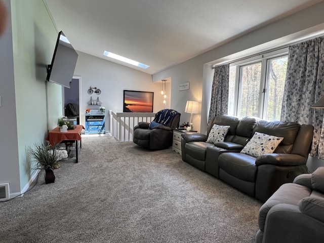carpeted living area with vaulted ceiling, a skylight, and baseboards