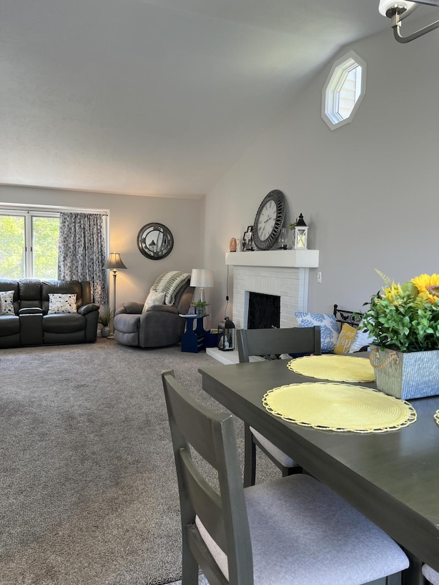 dining room featuring a fireplace, plenty of natural light, carpet flooring, and lofted ceiling