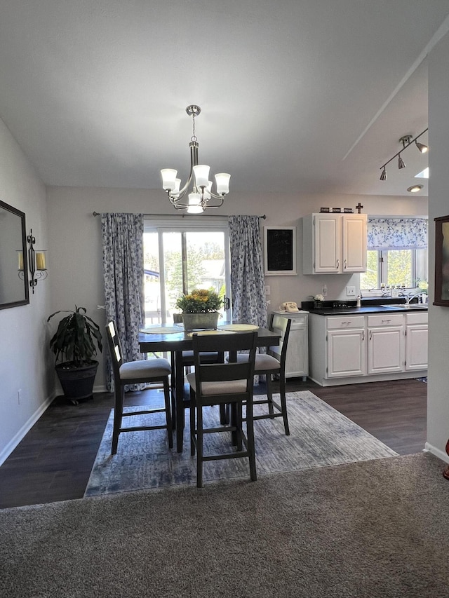 dining area with a chandelier, baseboards, and dark wood-style floors