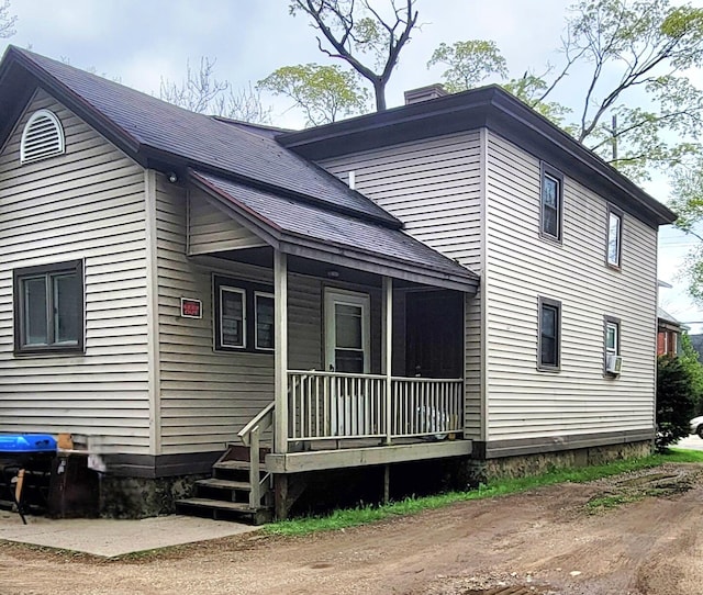 1123 Mills St, Kalamazoo, MI 49001 - view of home's exterior featuring a porch, a chimney, and a shingled roof