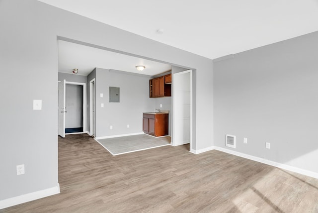 18250 Weaver St, Detroit, MI 48228 - unfurnished living room featuring electric panel, baseboards, and light wood-style floors
