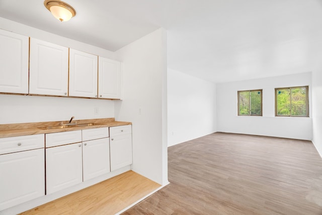 18250 Weaver St, Detroit, MI 48228 - kitchen with a sink, light wood finished floors, open floor plan, and white cabinetry