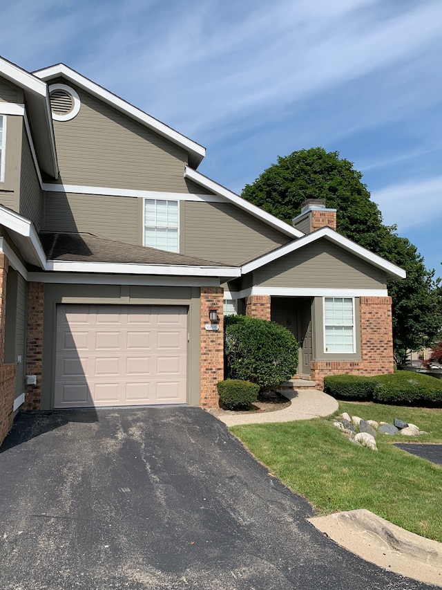 view of front facade featuring brick siding, a garage, and driveway