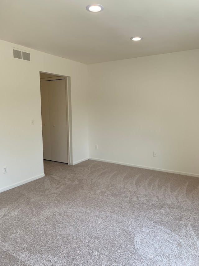 carpeted spare room featuring baseboards and recessed lighting