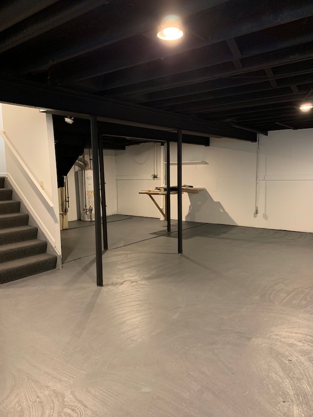 finished basement with gas water heater and stairs