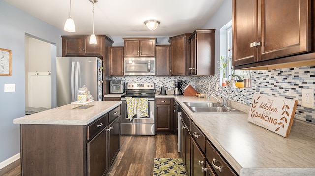 3242 Hill Hollow Ln, Howell, MI 48855 - kitchen with stainless steel appliances, a center island, dark wood-style flooring, a sink, and light countertops