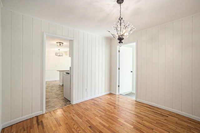 615 Garber Rd, North Muskegon, MI 49445 - spare room with a chandelier, light wood finished floors, and baseboards