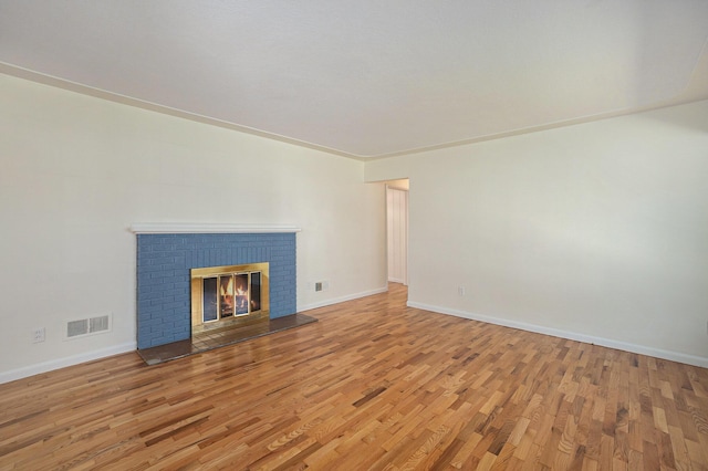 615 Garber Rd, North Muskegon, MI 49445 - unfurnished living room featuring wood finished floors, baseboards, and a brick fireplace