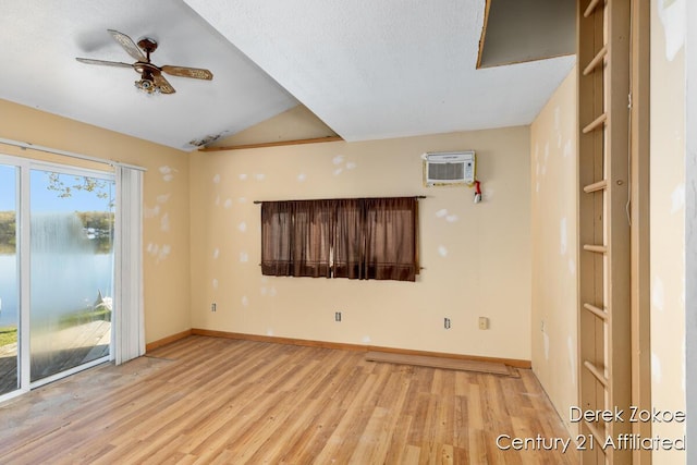 771 Sunny Trl, Greenville, MI 48838 - unfurnished room with wood finished floors, baseboards, a wall mounted AC, a ceiling fan, and vaulted ceiling