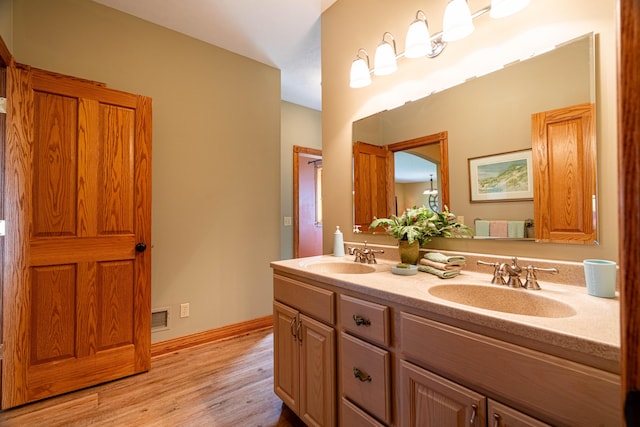 full bathroom with wood finished floors, double vanity, and baseboards