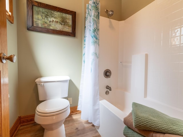 full bath featuring toilet, wood finished floors, shower / bath combo, and baseboards