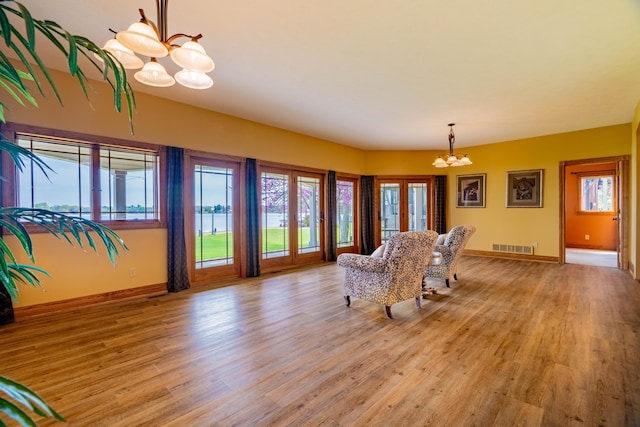 dining space featuring a chandelier, plenty of natural light, light wood finished floors, and baseboards
