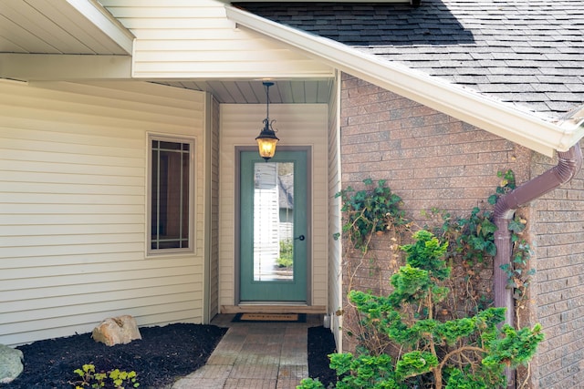 doorway to property featuring a shingled roof
