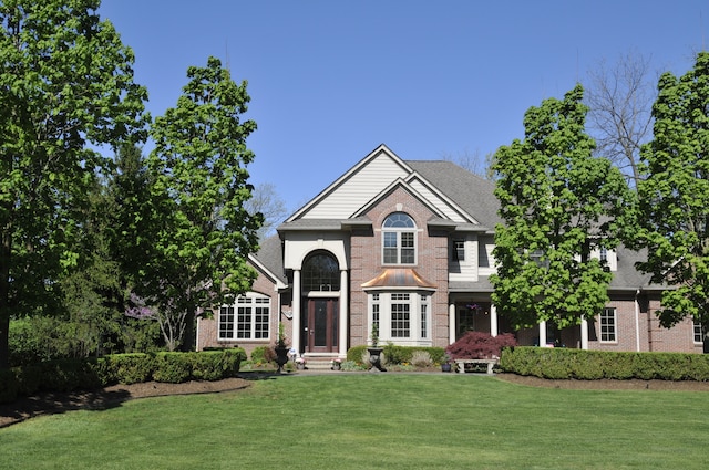 traditional-style house featuring brick siding and a front yard