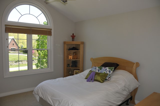 carpeted bedroom featuring vaulted ceiling and baseboards