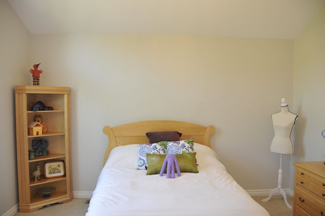 bedroom featuring light carpet and baseboards