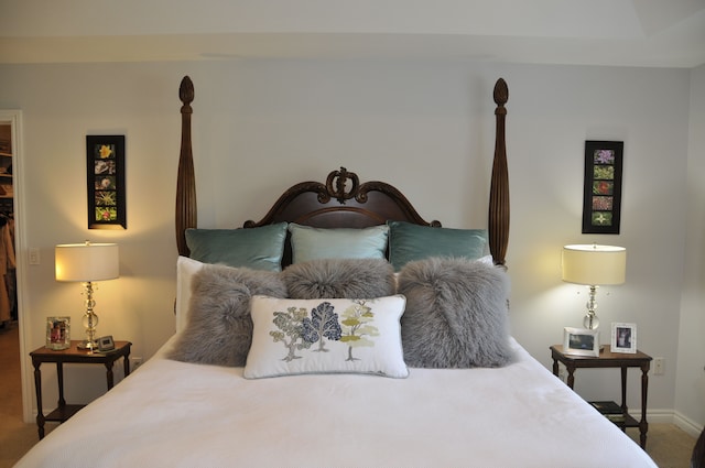 carpeted bedroom featuring a walk in closet, baseboards, and a closet
