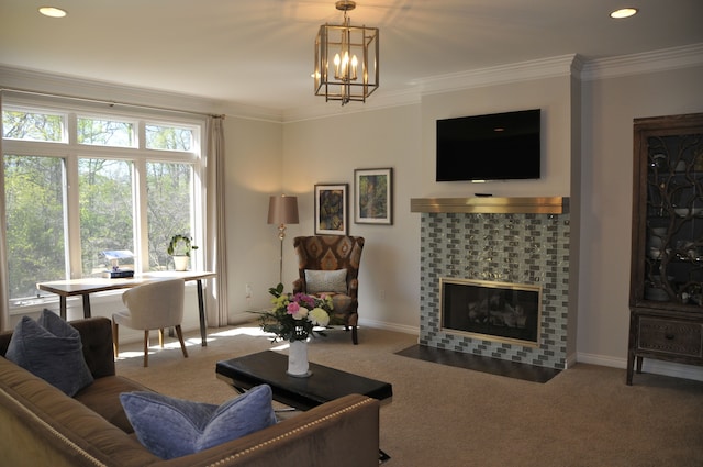 living room featuring crown molding, a chandelier, a tile fireplace, carpet flooring, and baseboards