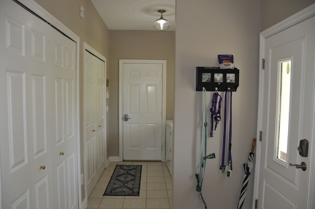 entryway with light tile patterned floors and baseboards