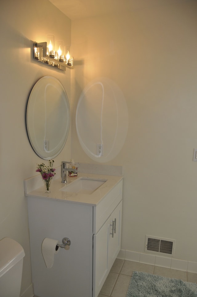 half bath featuring vanity, tile patterned flooring, toilet, a chandelier, and baseboards