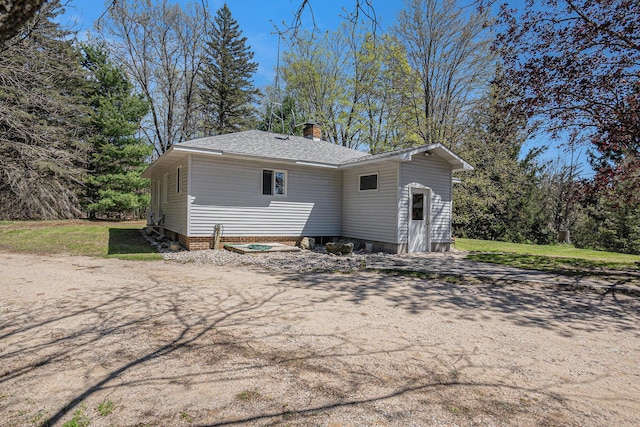 3771 E Loop Rd, Hesperia, MI 49421 - back of property with a chimney and roof with shingles