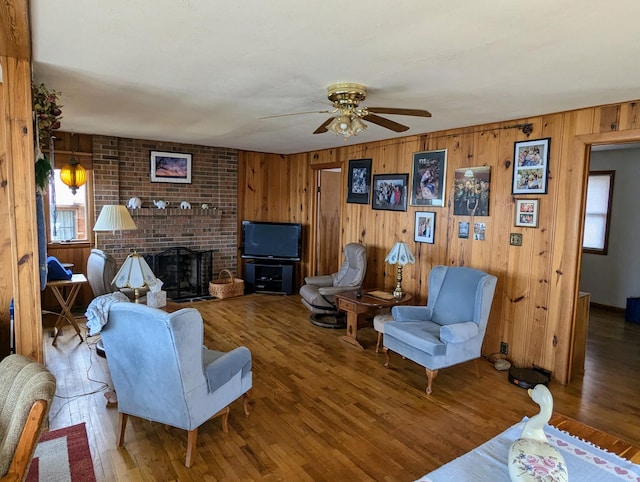63568 Zabel Shores Rd, Sturgis, MI 49091 - living room with a ceiling fan, wooden walls, wood finished floors, and a fireplace