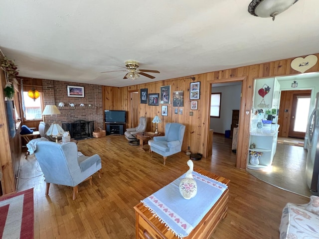 63568 Zabel Shores Rd, Sturgis, MI 49091 - living area featuring wooden walls, ceiling fan, wood finished floors, and a fireplace