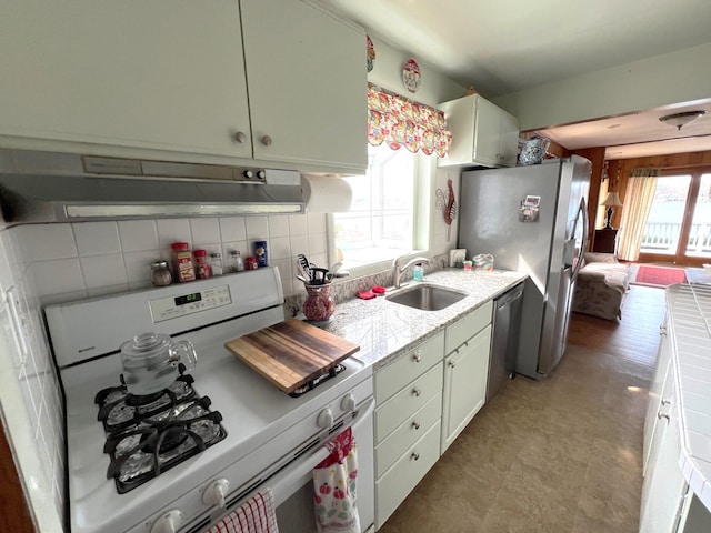 63568 Zabel Shores Rd, Sturgis, MI 49091 - kitchen featuring appliances with stainless steel finishes, under cabinet range hood, a sink, backsplash, and white cabinetry