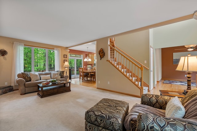 3135 Walnut Hls, Leonard, MI 48367 - living area with healthy amount of natural light, stairs, light colored carpet, and a chandelier